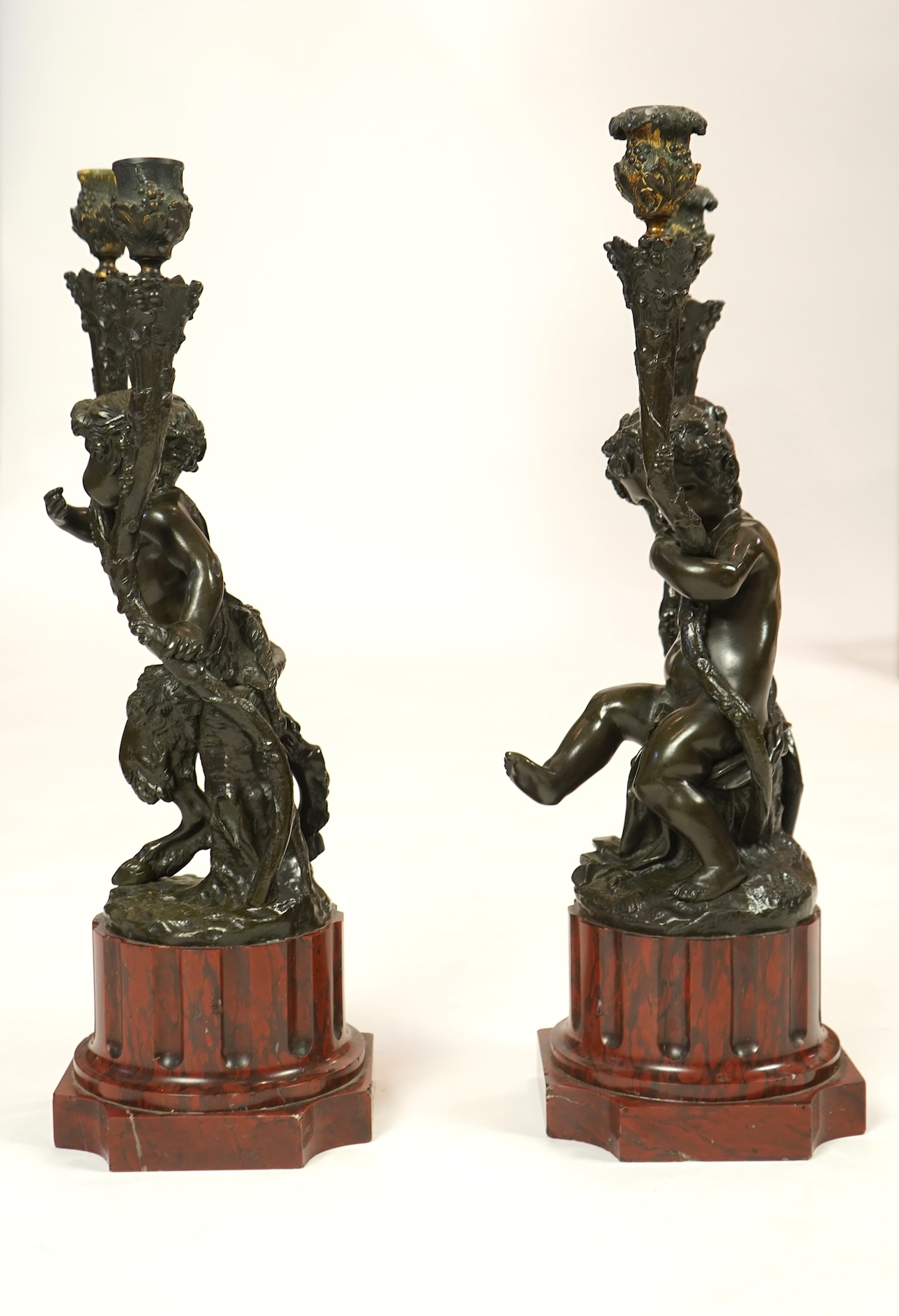 After Clodion. A pair of mid 19th century French bronze two branch figural candelabra